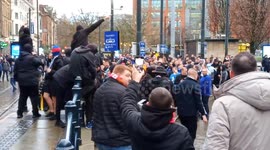 Football fans, including MUFC and Rangers fans, assemble and sing next to Market Street Metrolink tram stop, Piccadilly, central Manchester UK before the match between Manchester United Football Club and Rangers Football Club at Old Trafford ground on 23r