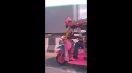 Tuk-tuk covered in Hello Kitty teddy bears cruises along road