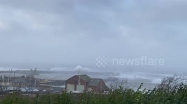 Waves crashing over the west pier at Whitehaven