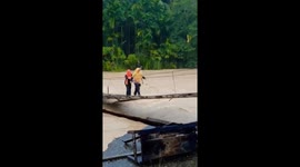 Tense scene of residents crossing a suspension bridge amidst floods in Indonesia