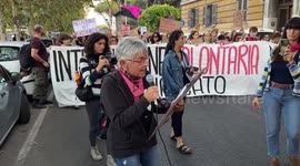 A feminist activist reads information from a sign during the march in the demonstration for the right to abortion organized by the Not One Less movement in Rome.