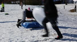 Families have fun sledding down a hill after a rare snowstorm hits Southeast North Carolina, USA
