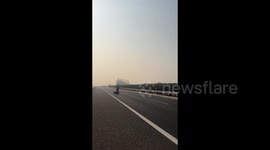 Motorist moves tyre blocking highway to roadside in China