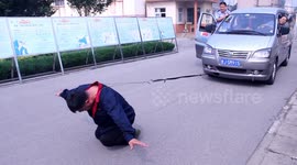 Kung fu man uses neck to pull minibus and sits backwards to drive motorcycle