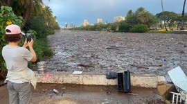 Tourists taking pictures of River of trash in Waikiki hawaii | after heavy rain the Ala Wai Canal is full of trash. matresses, pillows, emtpy canisters, plastic bags…  not far from there pepppe pay $400 per night to stay at a hotel and lay at beautiful Wa