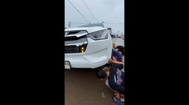 Locals jack up car to rescue stray dog sheltering from rain trapped underneath