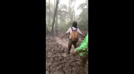 Hiker slides down muddy mountain slope in Java, Indonesia