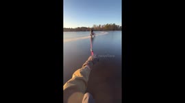 Friends slide across frozen lake in Järna, Sweden