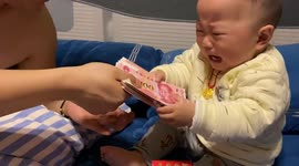 Baby stops crying as soon as he holds money in Guizhou, China