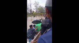 Residents carry flood victim in coffin on boat