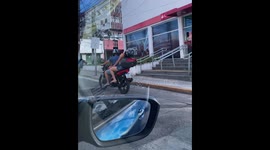 Woman falls asleep riding on the back of a motorcycle in Recife, Brazil