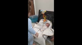 Toddler tries to sit on newborn sibling in Iran