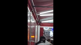 Goat in clothes sits at a chair eating kebab in Linares, Spain