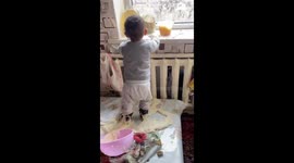 Baby makes dough mess in crib in Talas, Kyrgyzstan