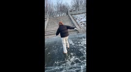 Person slides backwards on frozen lake in Jilin province, China