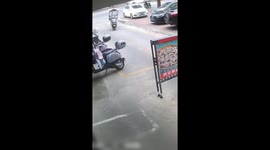 Motorcycle rider caught on the edge of a gate in Guangzhou, China