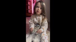 Child sings while holding cat in Istanbul, Türkiye