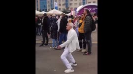 Charismatic man dancing with a glass of beer on his head!
