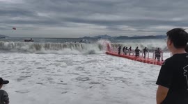 Tourists ride floating pontoons as waves hit them in China