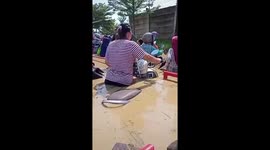 Scooter riders negotiate waist-deep floods in Indonesia