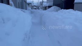 Resident walk through maze of snow blanketing streets in Japan