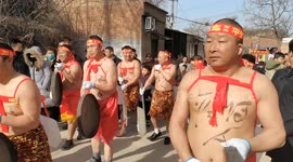 Topless men carry huge ice blocks on their back during parade in eastern China