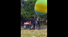 Office colleagues play with giant volleyball for party game