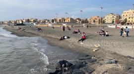 People on the beach of Lido di Ostia on a peaceful sunny day in October in Rome.