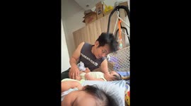 Little boy's giggles break the peace while his cousin sleeps peacefully beside him