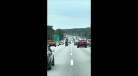 Modified motorbike with four wheels cruises along Malaysia highway