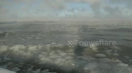 Ice in raging waves. Water vapor rises in columns and forms clouds over Lake Baikal.
