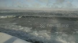 The sea rolls ice to the shore and dandles it on the waves