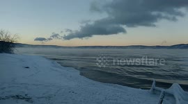 Lake Baikal at sunset. The water is steaming and the waves are pushing the shore