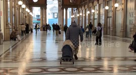 A homeless man carries his belongings on a makeshift trolley through the Galleria Sordi in Rome.