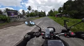 Motorbike rider almost collides with oncoming scooter rider switching lanes