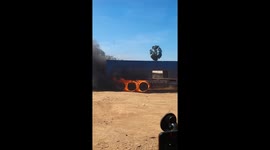 Truck with burning wheels rattles along dusty road