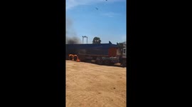 Truck with burning wheels rattles along dusty road