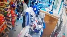 Axe-wielding robber threatens shopkeeper before brave wife fights back