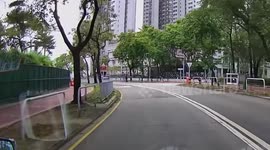 Pedestrian takes a tumble while trying to climb over road barrier
