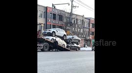 Bizarre scene as vehicles stacked on top of each other are driven onto tow truck in China