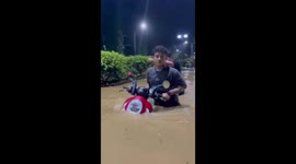 Locals wade through chest-deep floods in Indonesia