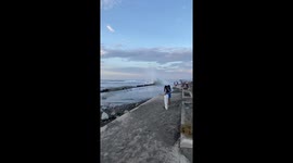 Wave crashes along barrier like dominos falling