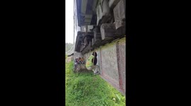 Fearless engineers hang from bridge as train thunder above their heads
