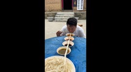Chinese man eats long noodles through four bowls of soup