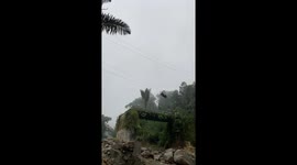 Locals use zip line to transport motorcycle across river