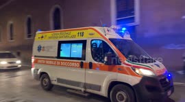 An ambulance travels at high speed with sirens blaring along a downtown street on the evening of Valentine's Day in Rome.