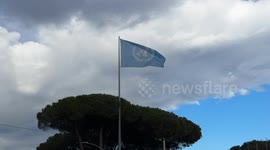 The United Nations flag flutters in the wind against a partly cloudy sky on a February day in Rome.