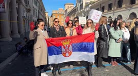 Protesters from Serbia display red gloves while holding a Serbian flag during a demonstration in support of the Serbian student protests on Serbian National Day in Rome.