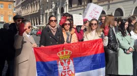 Protesters from Serbia display red gloves while holding a Serbian flag during a demonstration in support of the Serbian student protests on Serbian National Day in Rome.