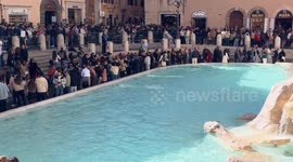 Overview of the Trevi Fountain and the square in front full of tourists on a bright February day in Rome.
